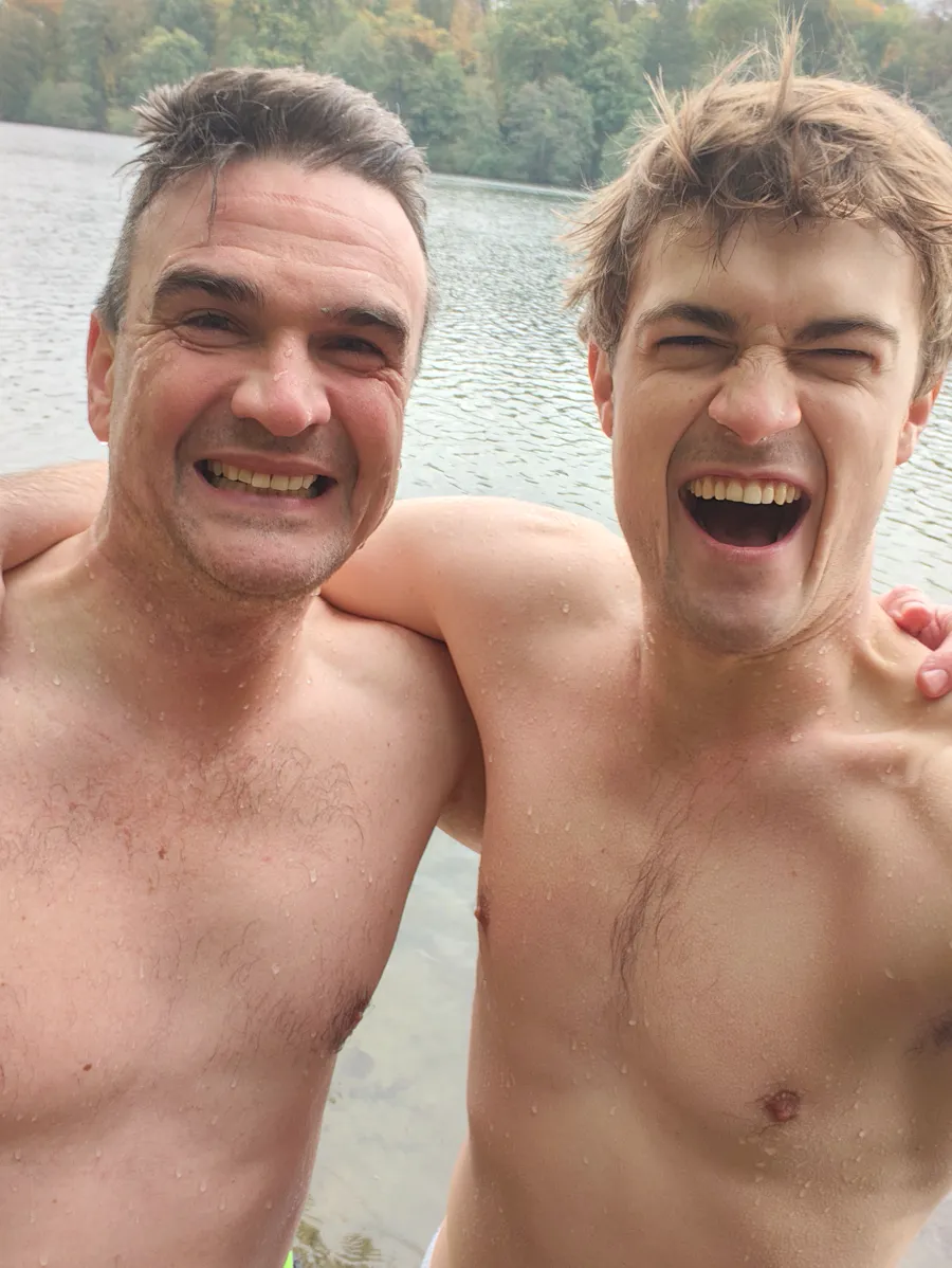 Ben and Max laughing, arms around each other, still wet after an ice bath