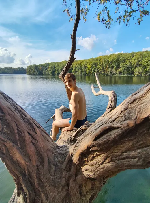 Max sitting on a tree trunk above the lake